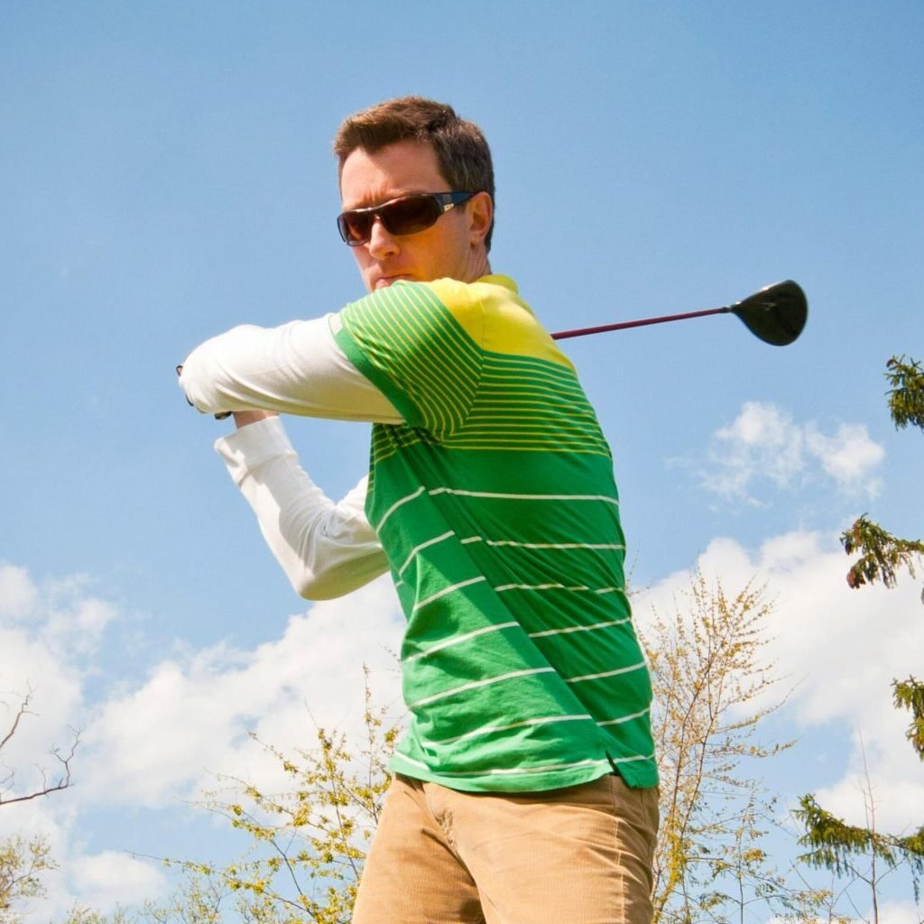 Man in Green and White Stripes Long Sleeve Shirt Holding Black Golf Club