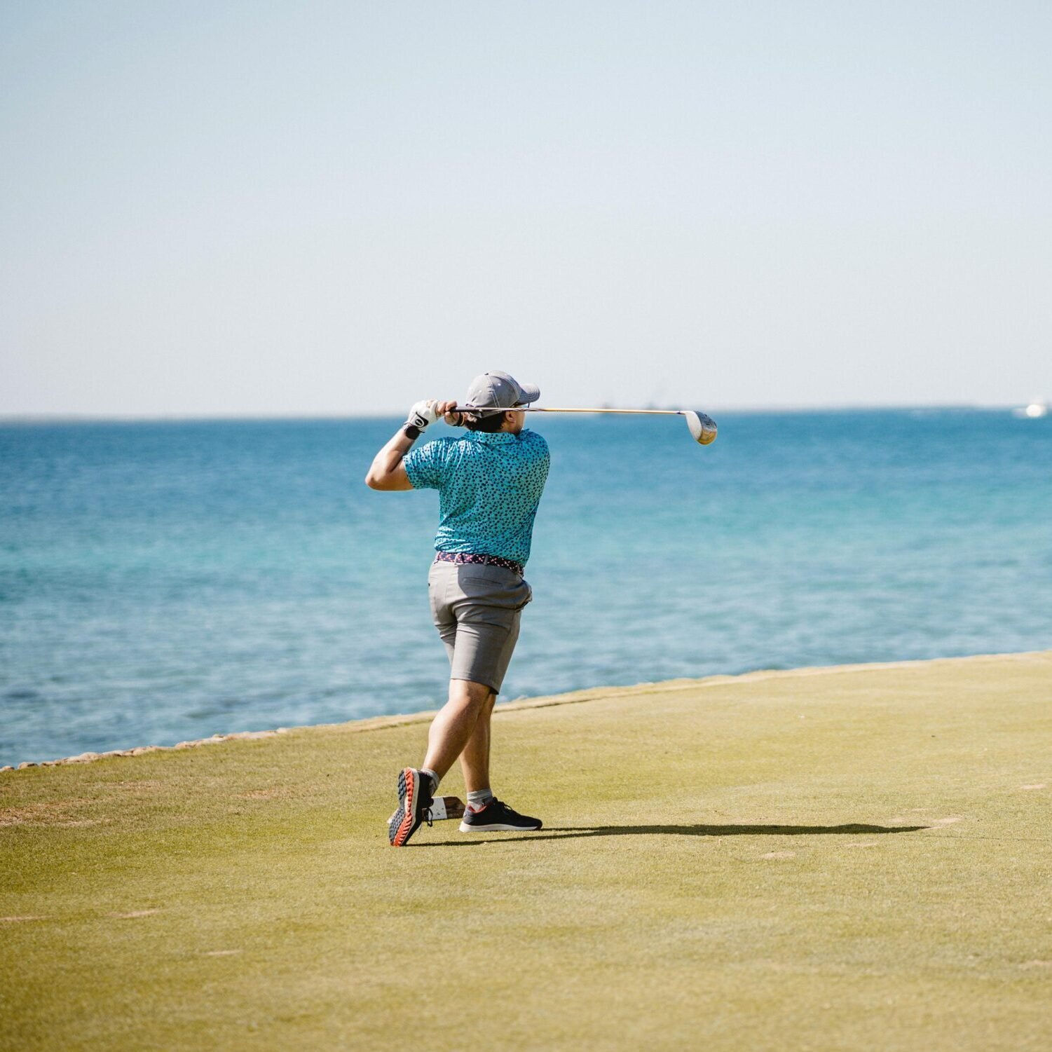 Man Playing Golf by Sea