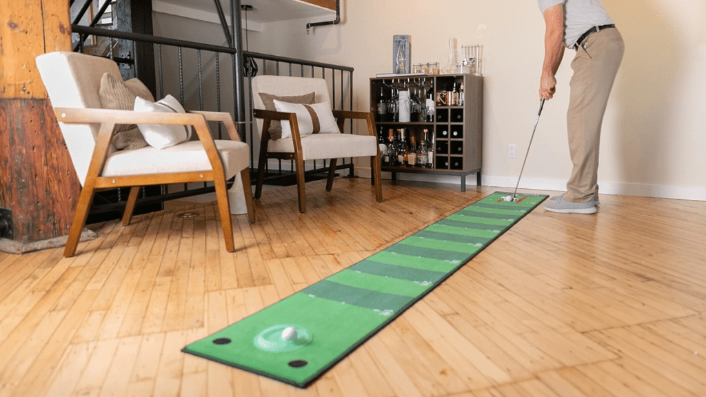 A man practicing his putting skills on a Truebirdie golf putting mat indoors.